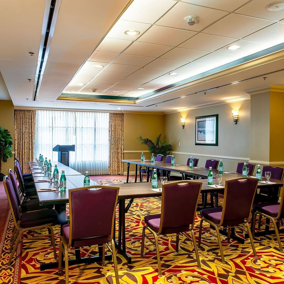 A meeting room with tables, chairs, and a window.