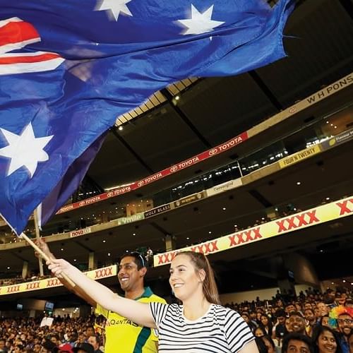 Image of a crowd cheering up with the Australian flag