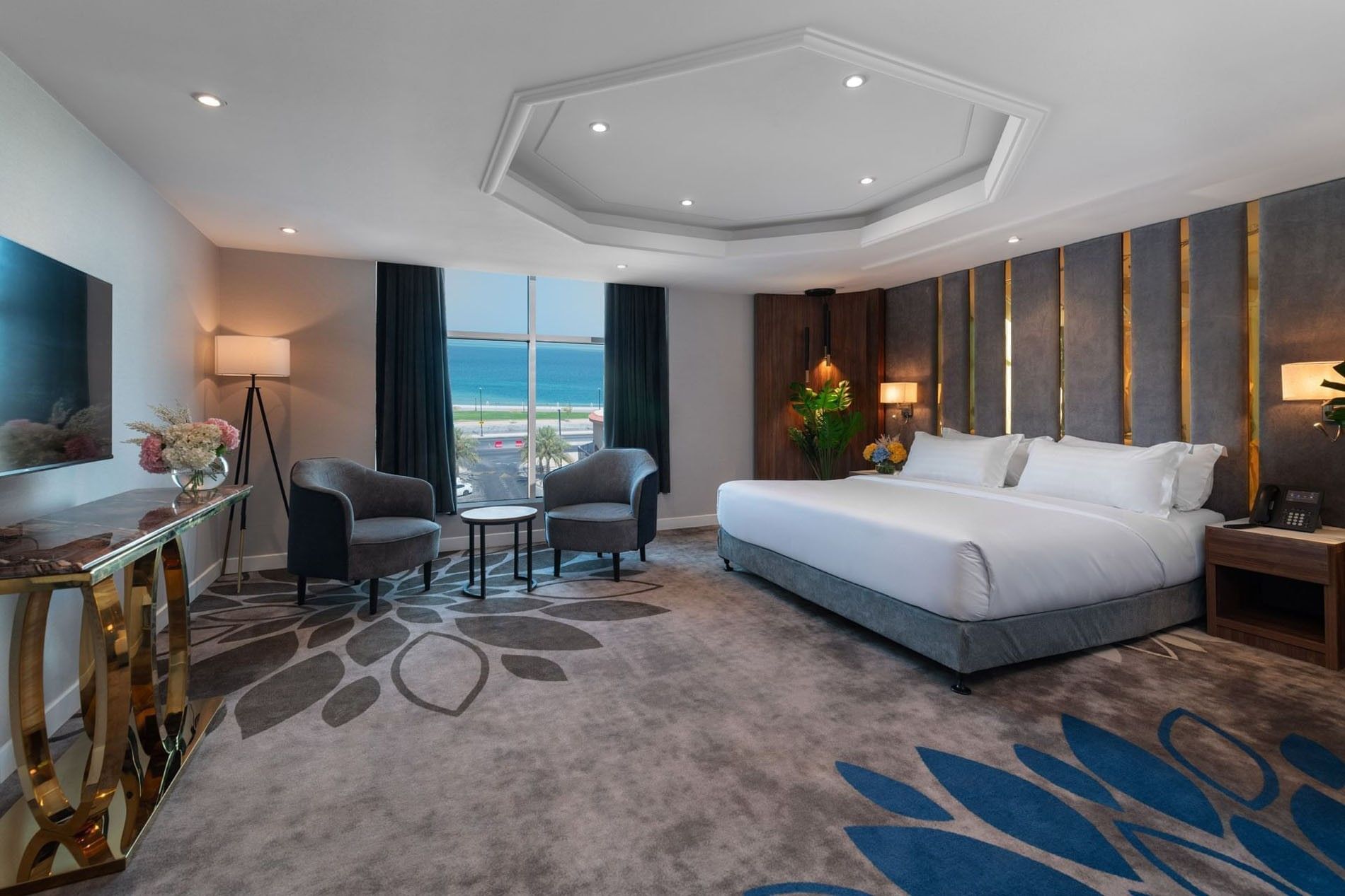 Royal Suite Sea View features King Bed & two grey armchairs by a window at Warwick Al Jubail