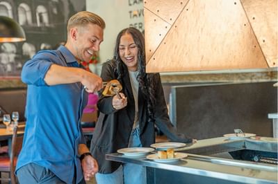 A couple dining at Pacini restaurant buffet near Acclaim Hotel Calgary