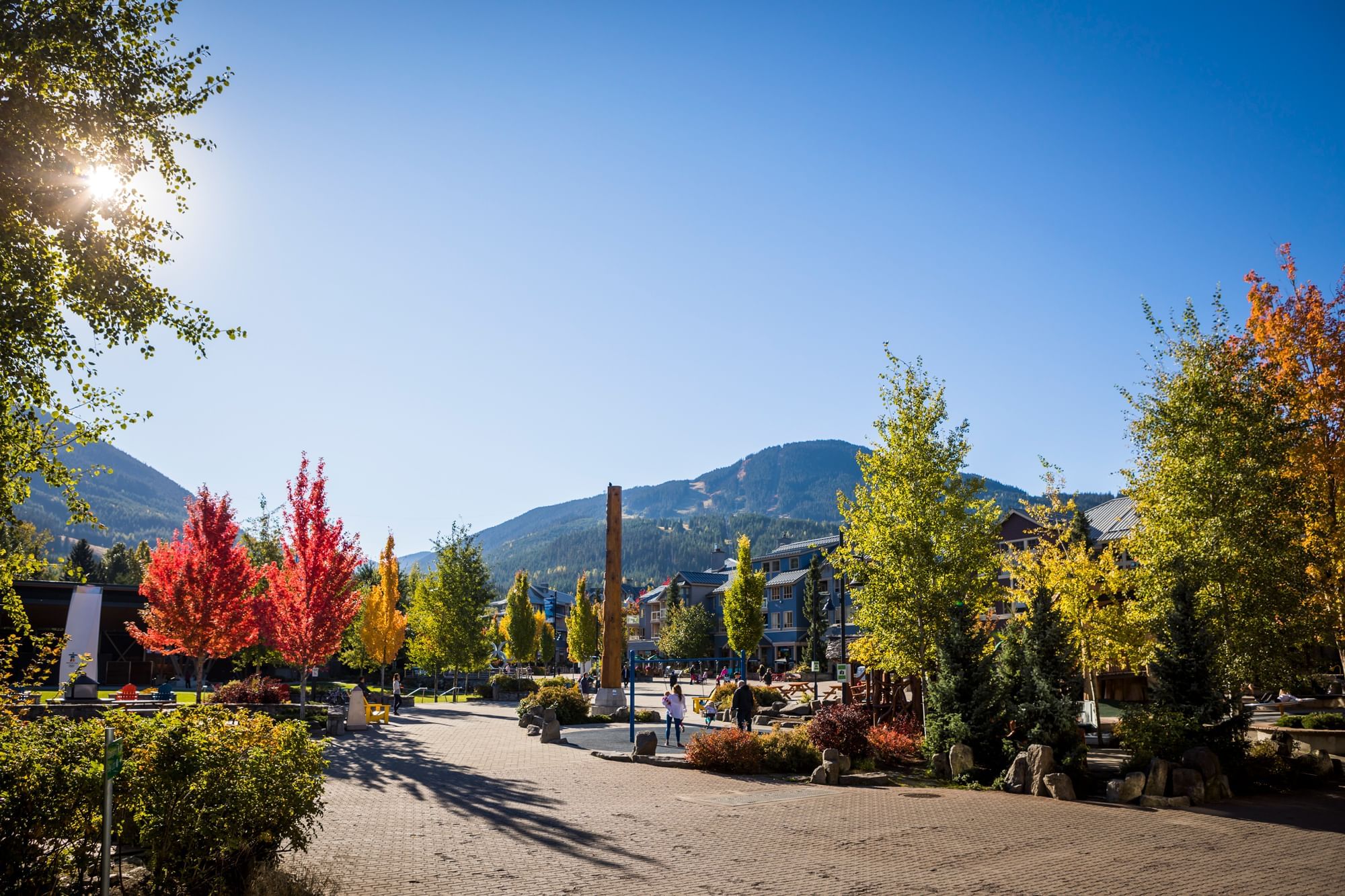 Scenic fall walkway with colorful trees in Whistler Village Stroll near Blackcomb Springs Suites