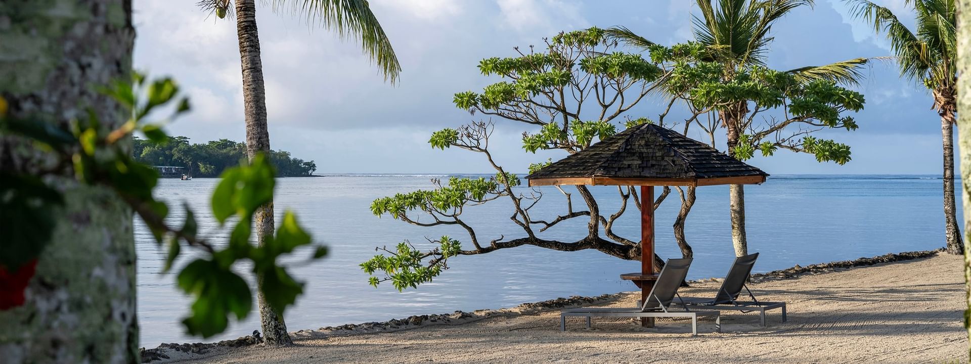 Beach with lounge chairs and umbrella at Warwick Le Lagon - Vanuatu, Efate