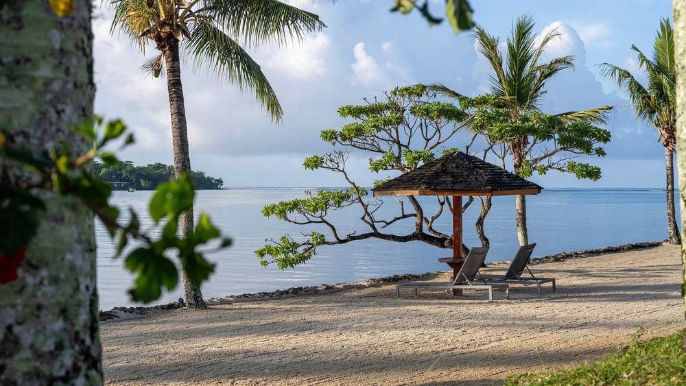 Beach with lounge chairs and umbrella at Warwick Le Lagon - Vanuatu, Efate.