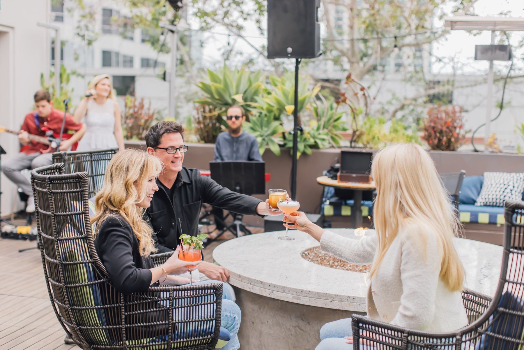 People toasting cocktails in Topside Terrace Kitchen & Bar at Hotel Republic San Diego