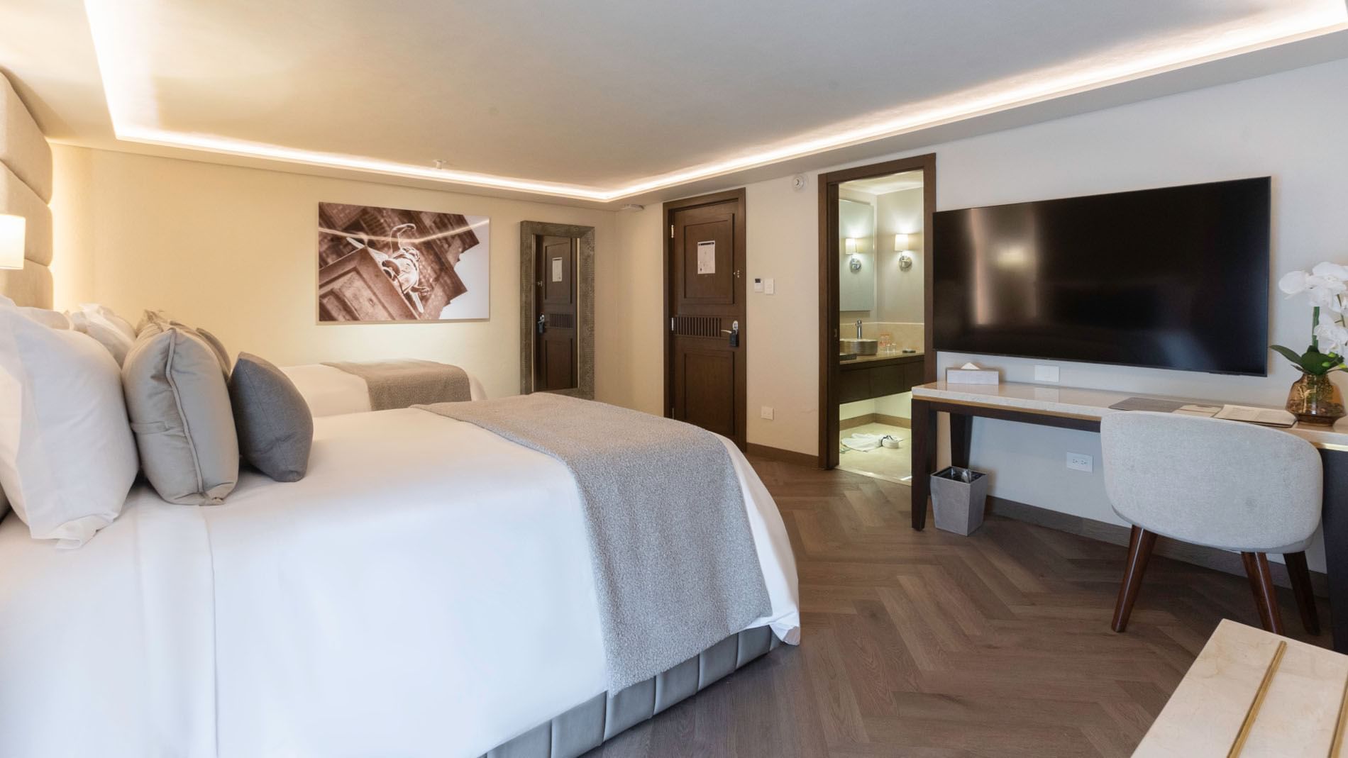 Two Double Deluxe featuring two twin beds, hardwood floors, and a sleek wall-mounted TV at Quinta Real Puebla