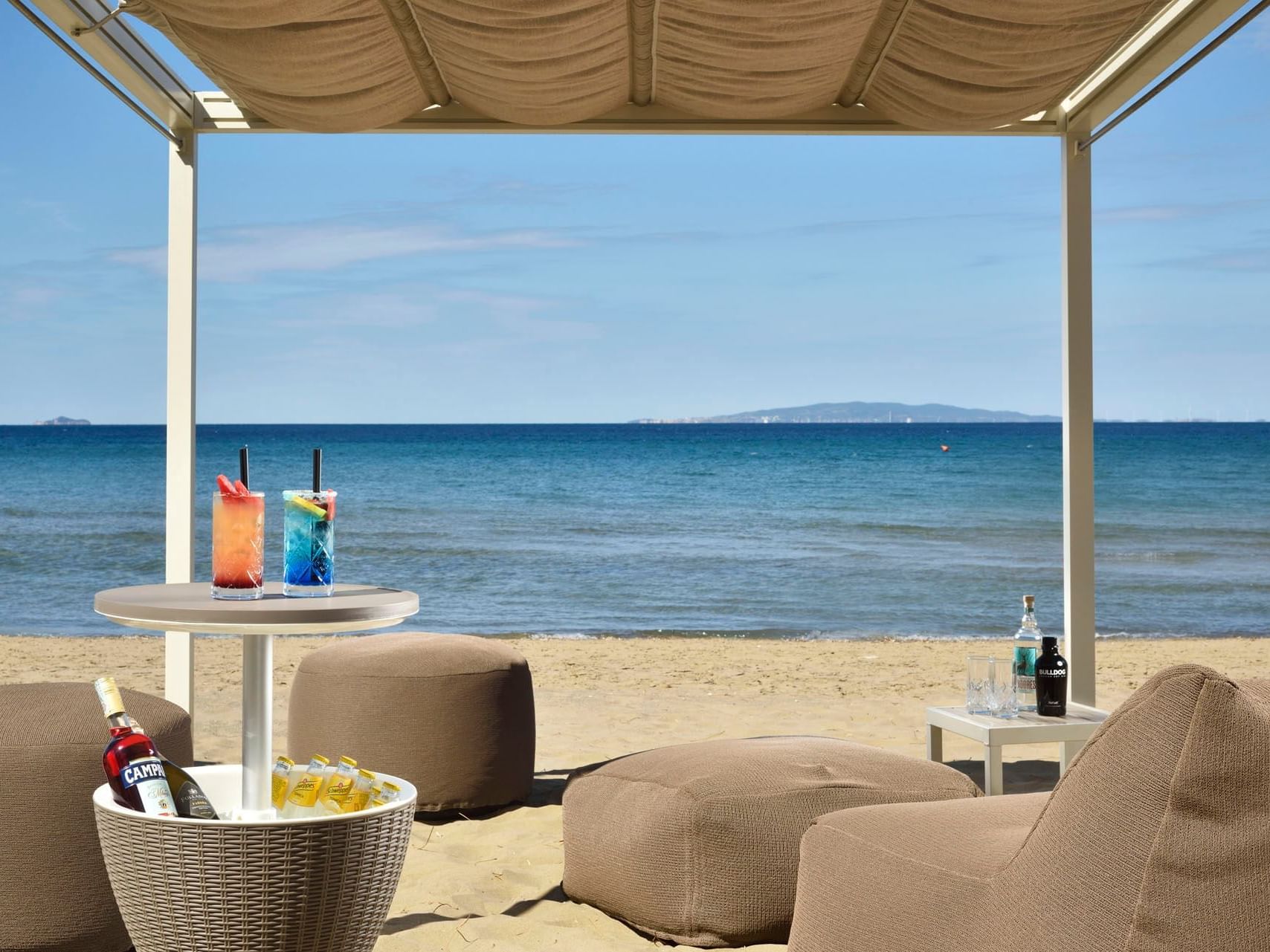 Outdoor dining & lounge area by the beach at Golf Hotel Punta Ala