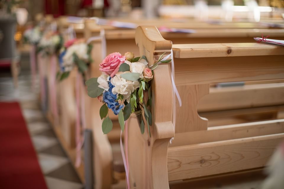 Close-up of wedding flower decors on pews at Liebes Rot Flueh