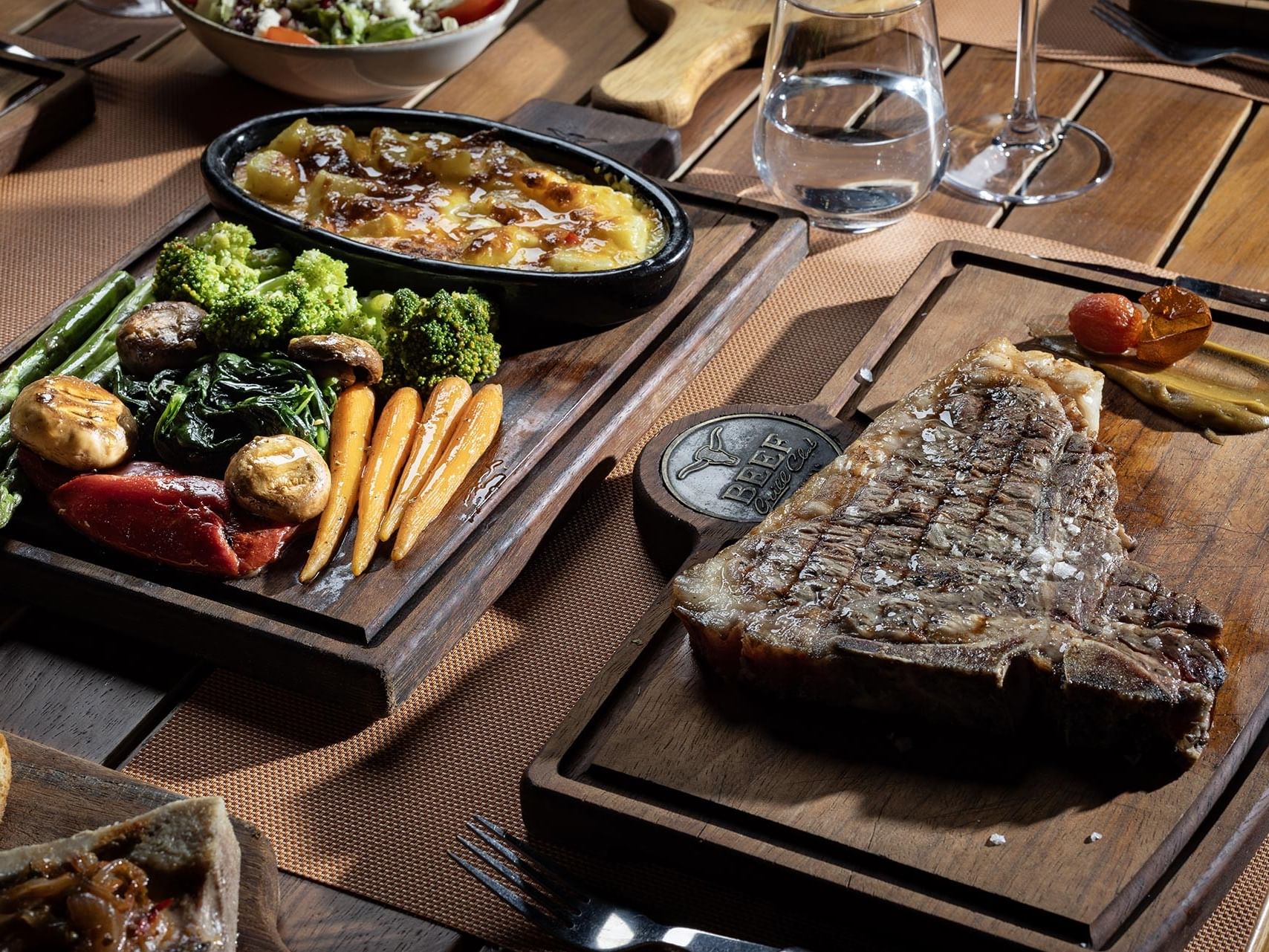A rich table setting on a wooden table at Titanic Luxury Collection Bodrum.