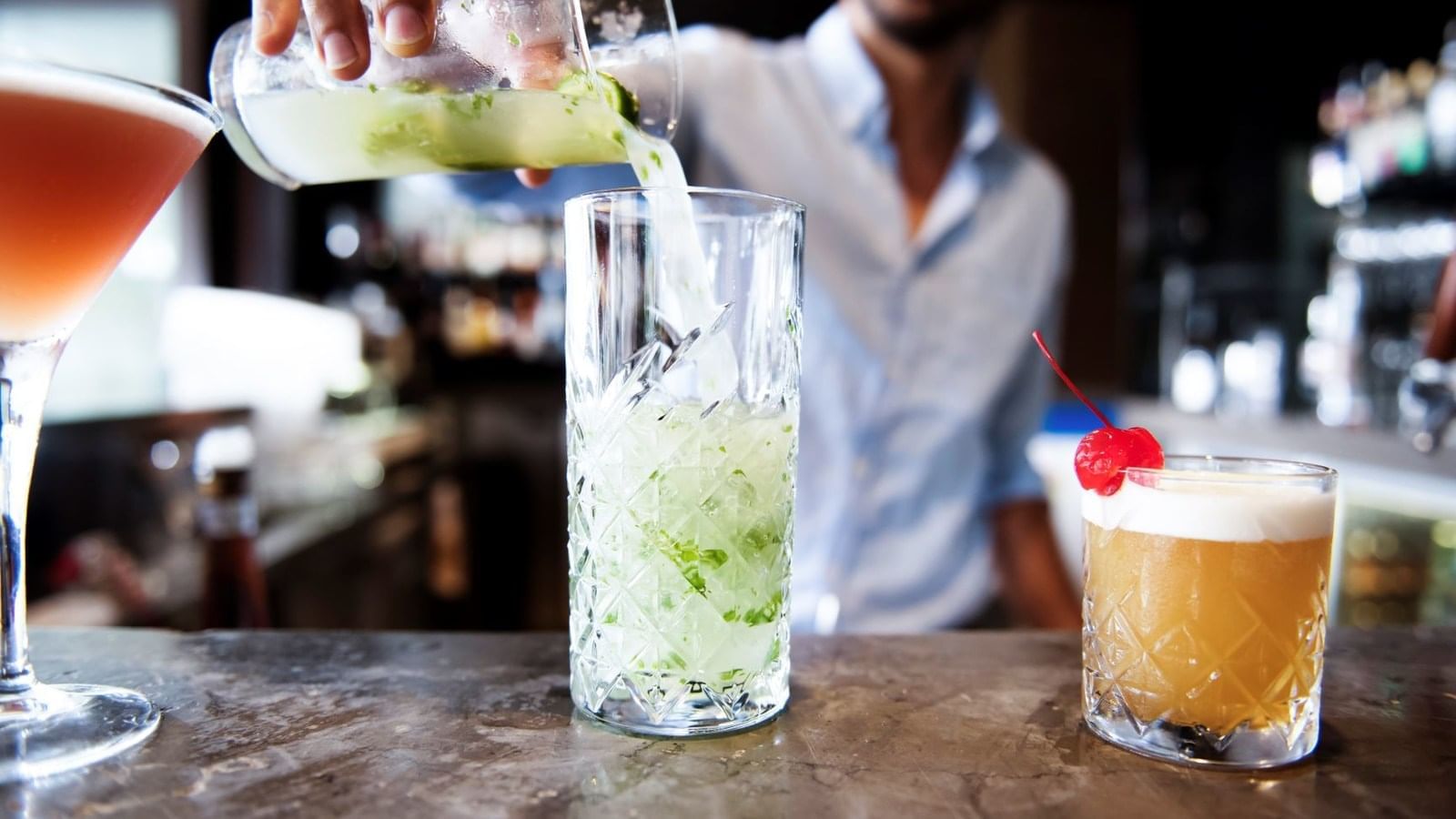 A man pouring a drink at pullman port douglas sea temple resort and spa