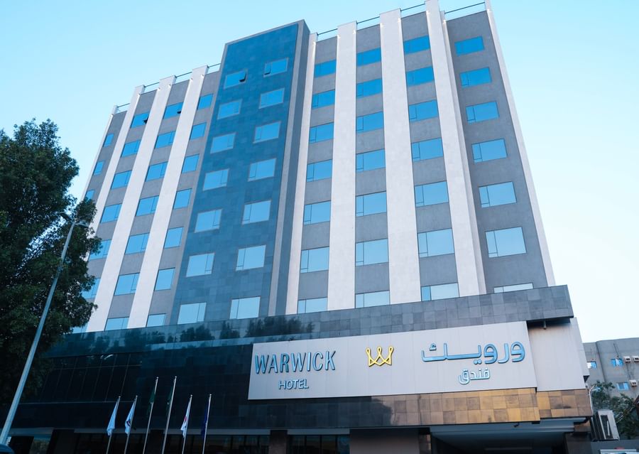 Warwick Hotel & Spa - Jeddah building with flags at entrance.