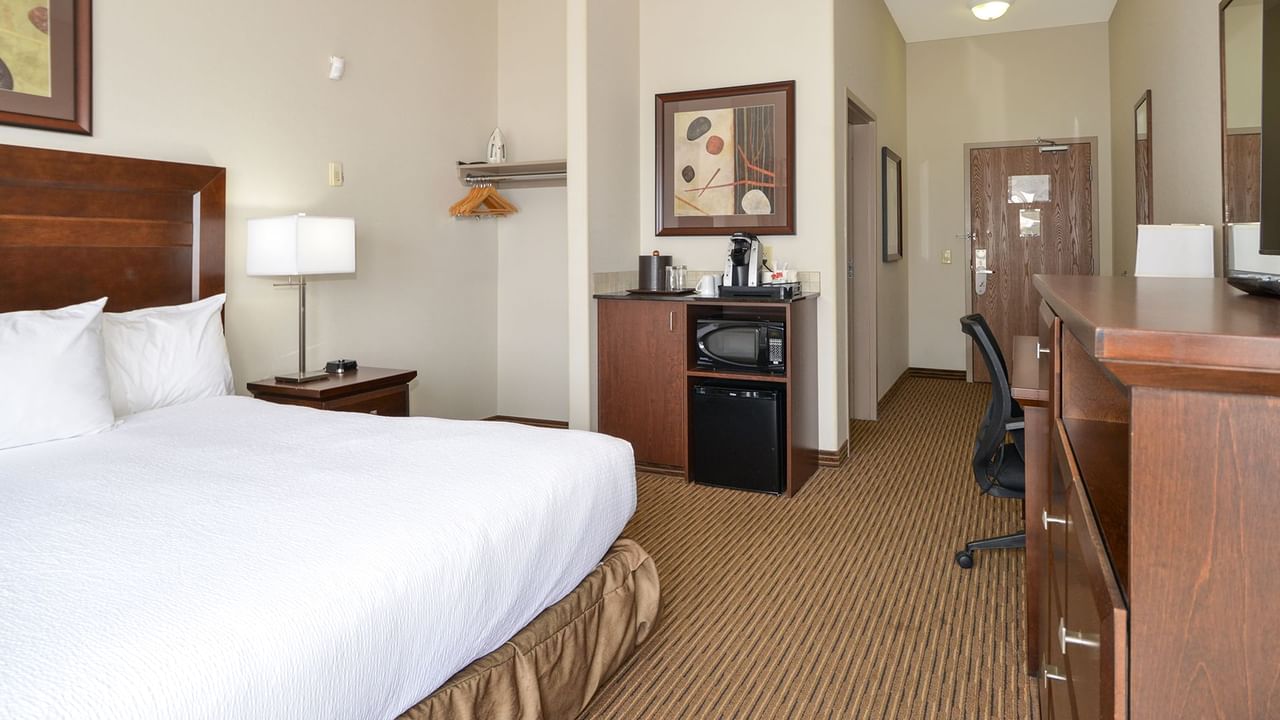 Accessible hotel room with king bed, mini fridge, coffee machine, work desk and chair