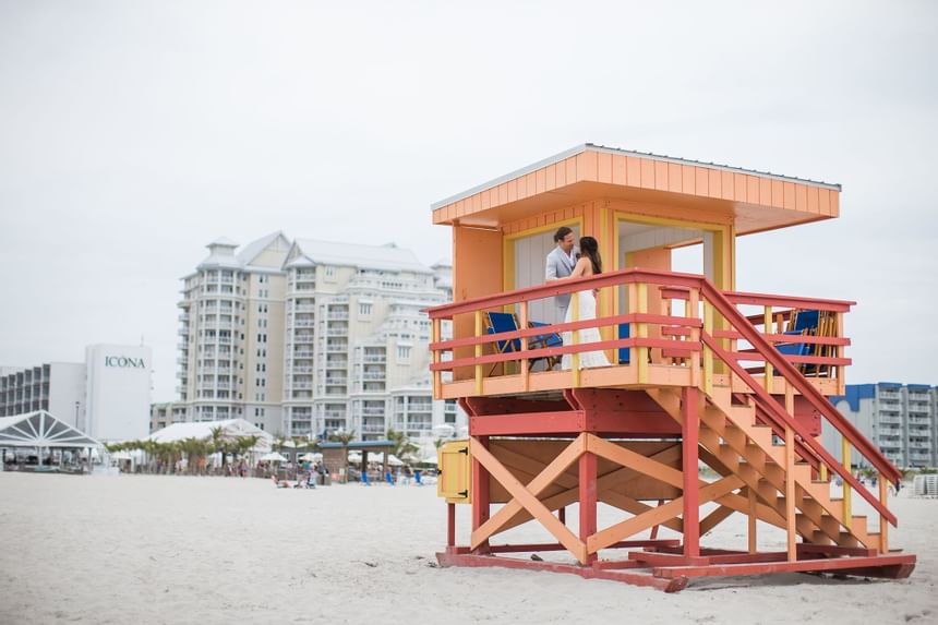 Newlyweds pose for a photo on the lifeguard station near our Diamond Beach wedding venue