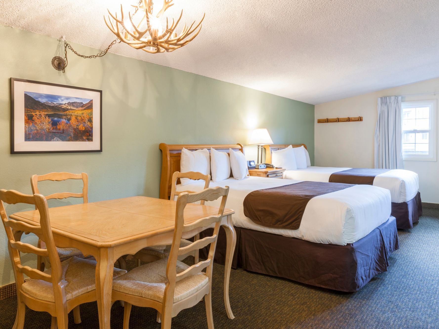 Two beds and dining table in Queen Studio at Alpenhof Lodge