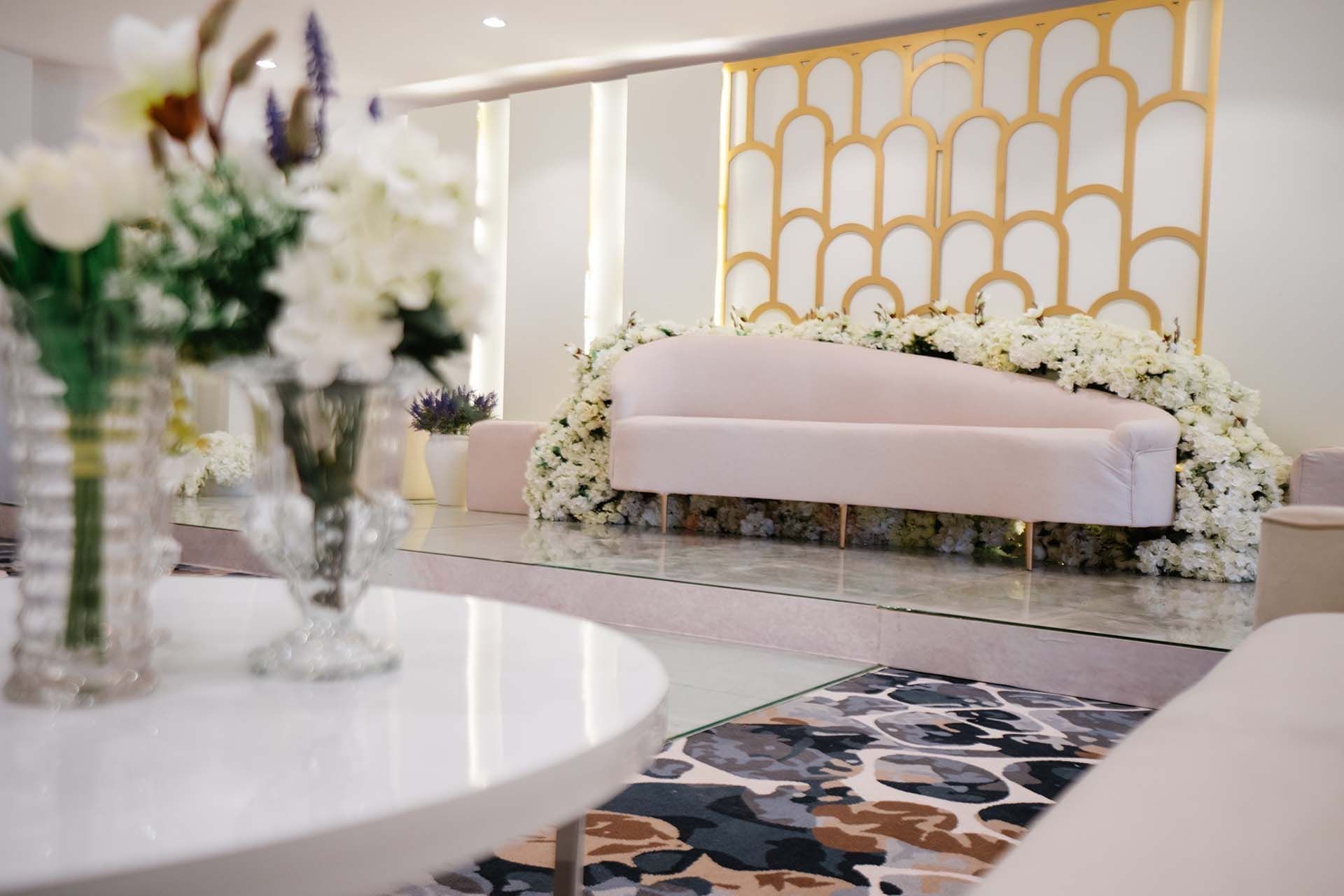 White velvet sofa by a white flower garland in Crystal Ball room at Cantonal Hotel by Warwick Riyadh