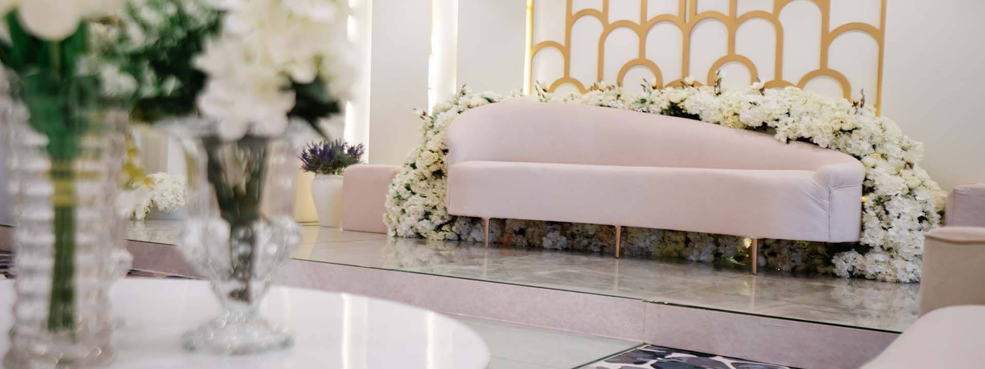 White velvet sofa by a white flower garland in Crystal Ball room at Cantonal Hotel by Warwick Riyadh