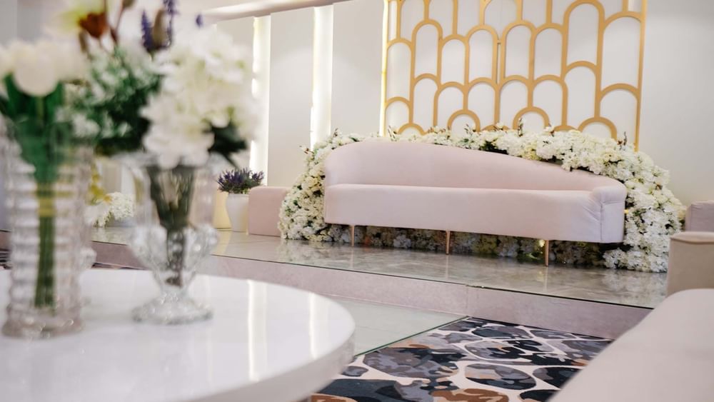White velvet sofa by a white flower garland in Crystal Ball room at Cantonal Hotel by Warwick Riyadh