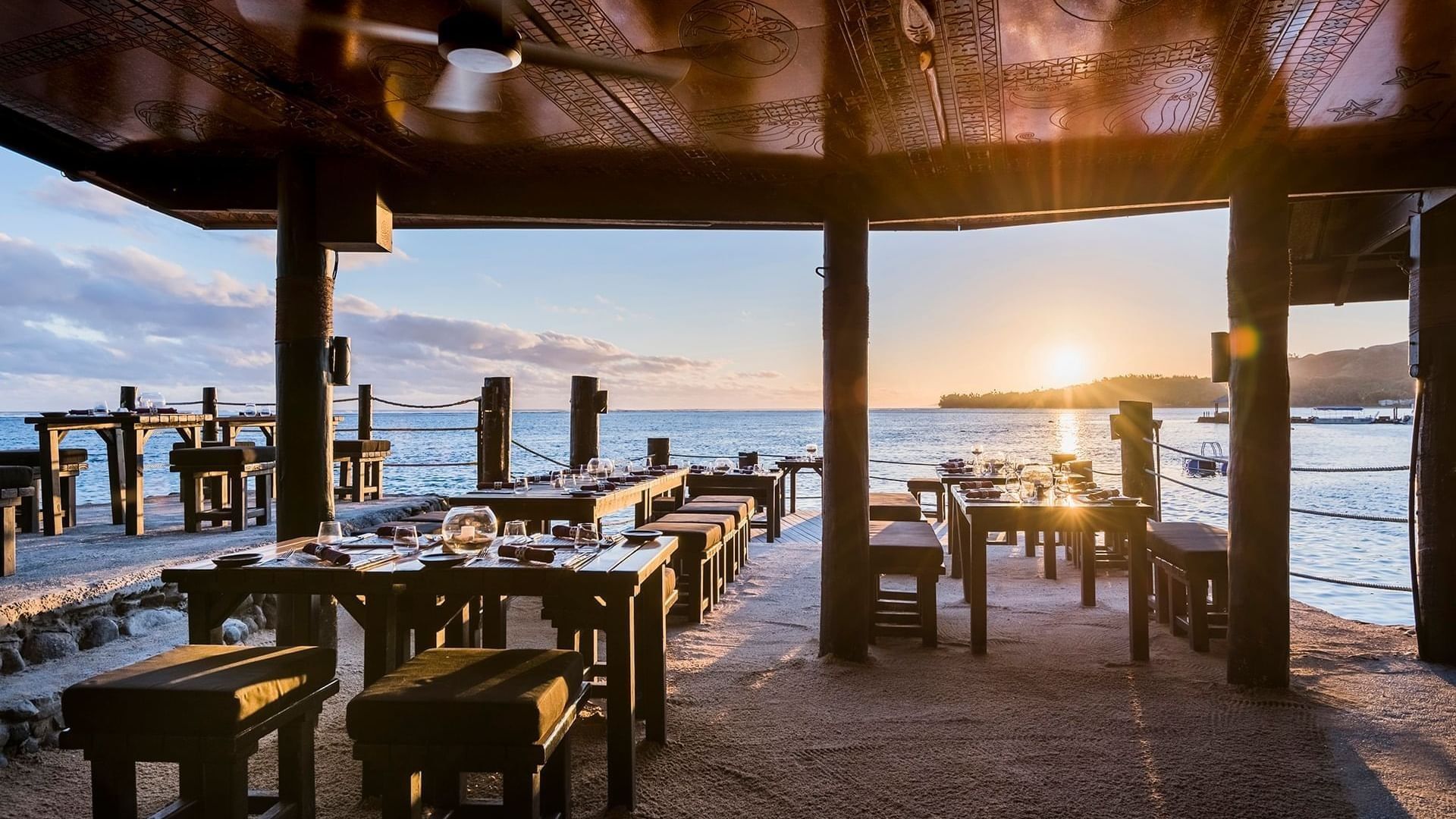Long wooden tables with benches by a rope fence at Warwick Fiji Resort and Spa