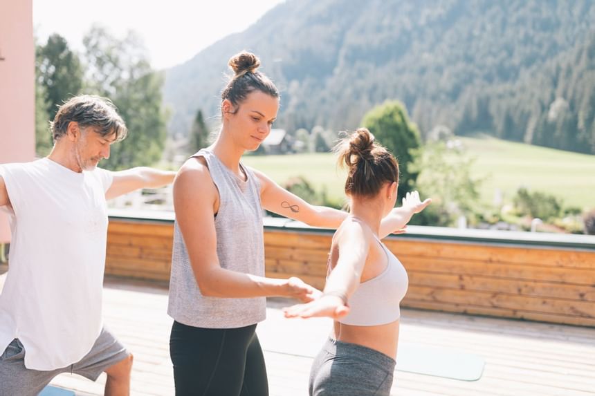 An instructor helping a lady to do Yoga at Liebes Rot Flueh