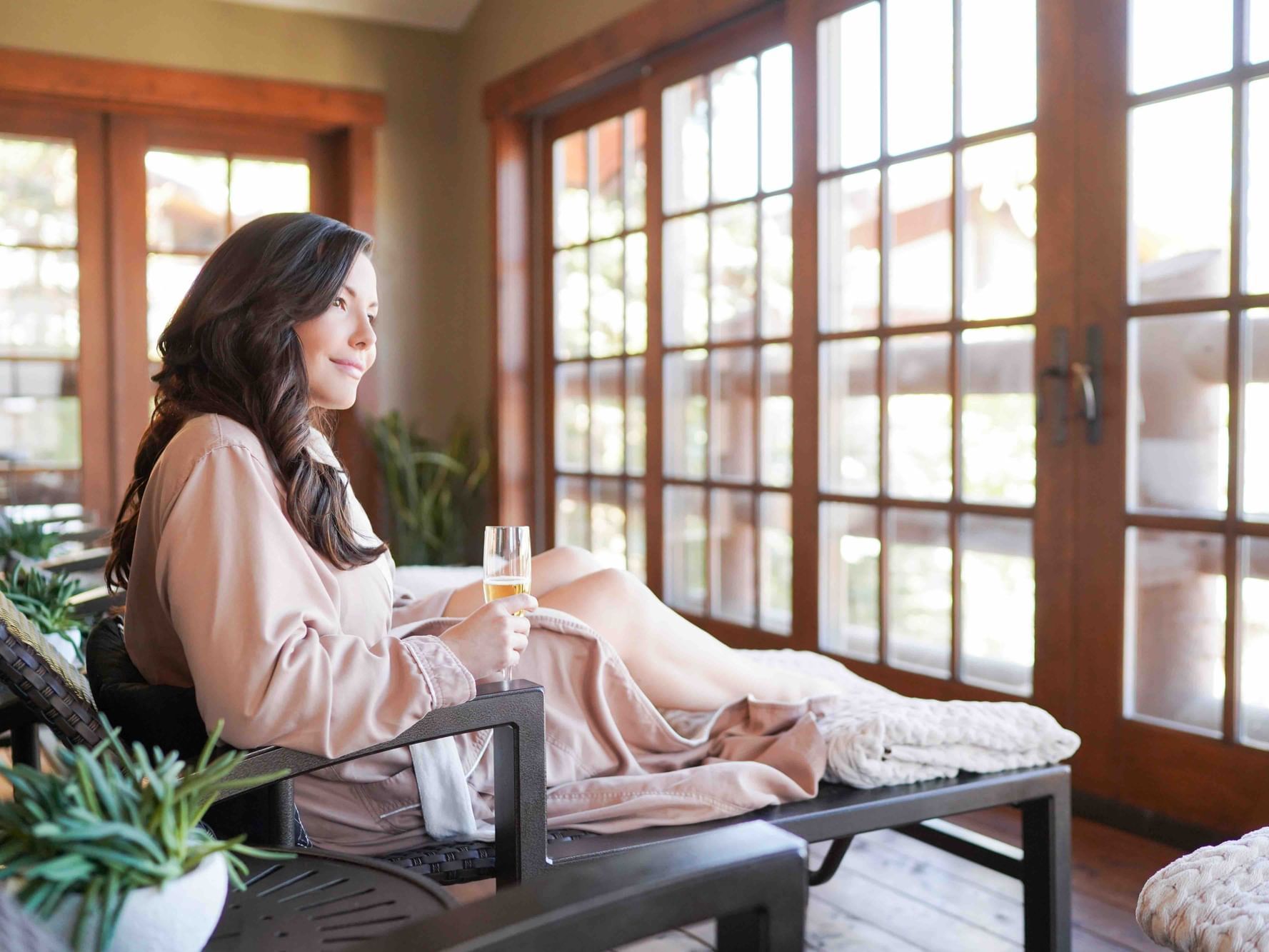 a woman in a lounge chair drinking champagne