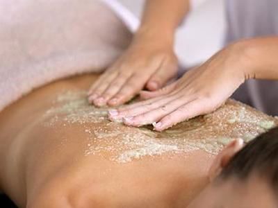 woman having back exfoliation treatment in spa at Amora Hotel