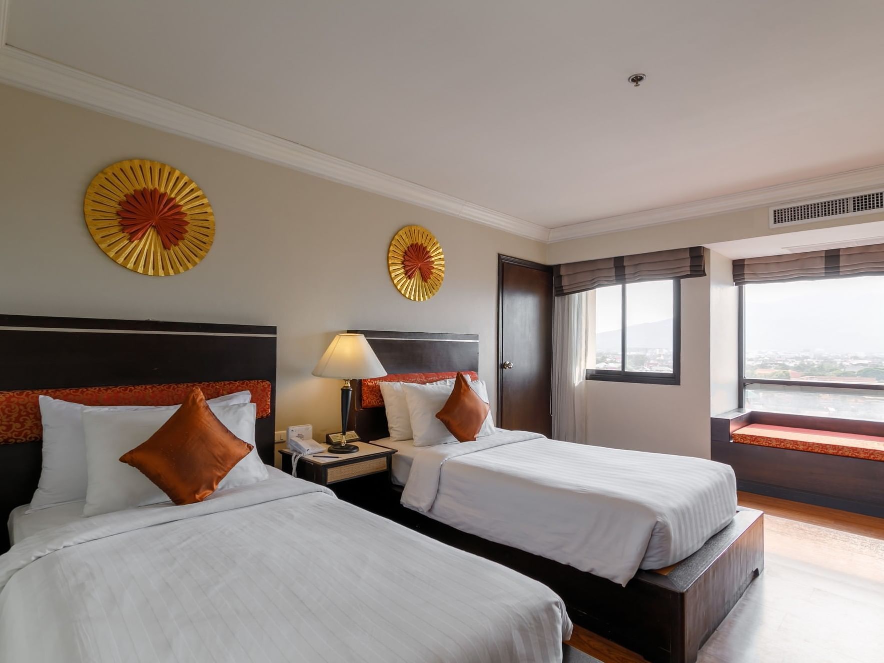 Two beds, lamp with window view in Duluxe Room at Amora Hotel