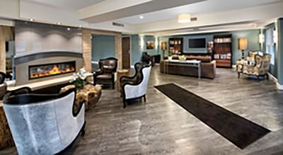 A stylish modern lounge area with a fireplace and wood floors at The Stanley Hotel, with chairs and sofas