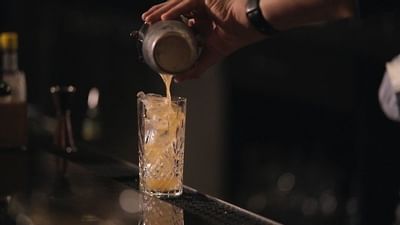 a bartender pouring a cocktail