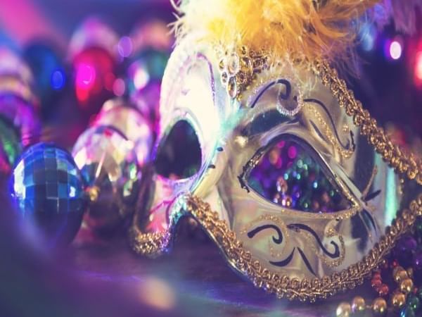 Mardi Gras mask adorned with colorful beads and feathers at La Galerie Hotel