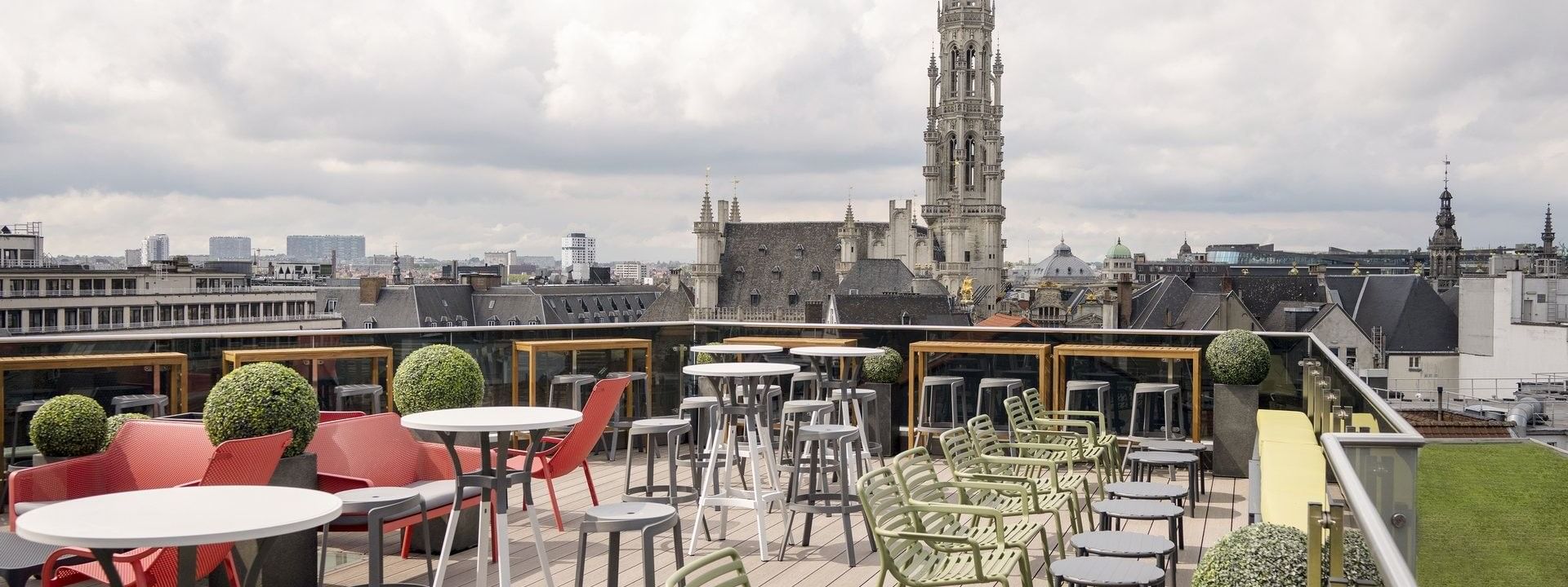Tafels en stoelen op het dakterras met uitzicht op de stad bij Secret Rooftop by Warwick in Brussel