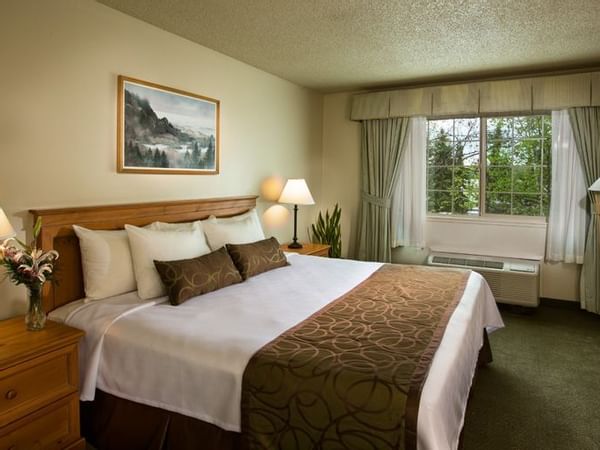 Bed in hotel room with window