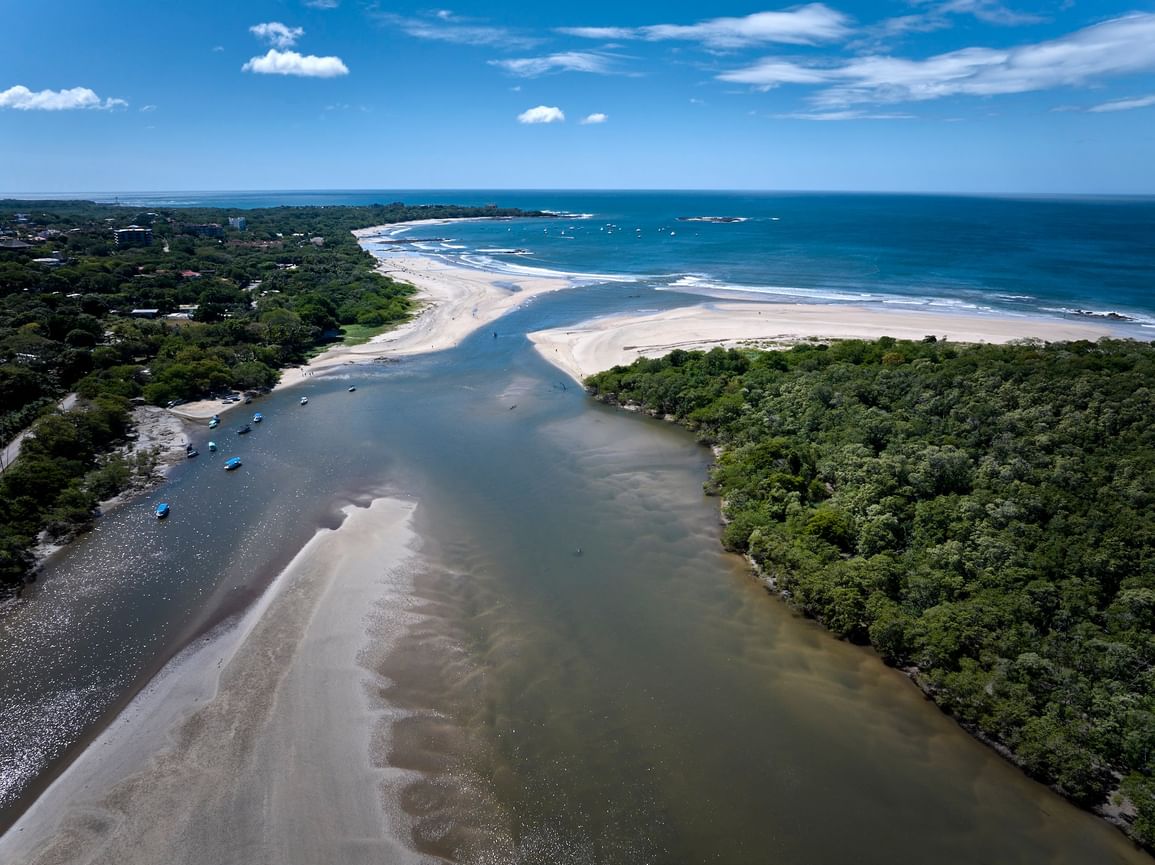 Stunning aerial view of the river meeting the ocean near Cala Luna Boutique Hotel