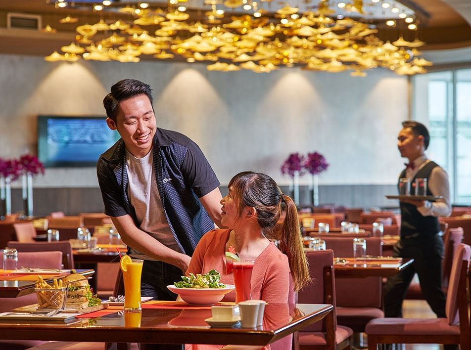 Man pulling a chair for woman in restaurant at Roselle Coffee House Lexis Hibiscus