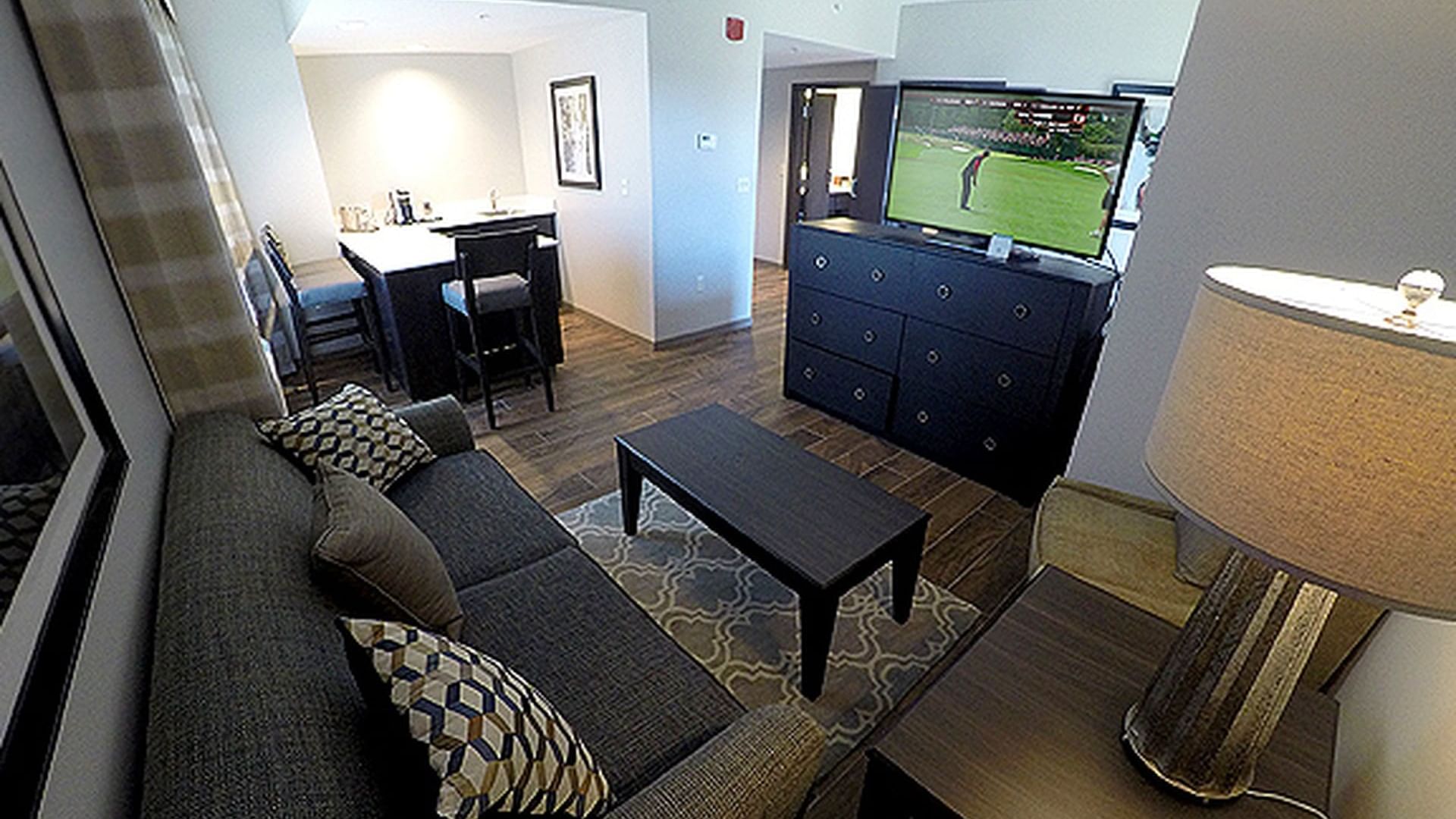 Cozy living area with a dark sofa, a coffee table, and a TV in Corner Suite at Shangri-La Monkey Island