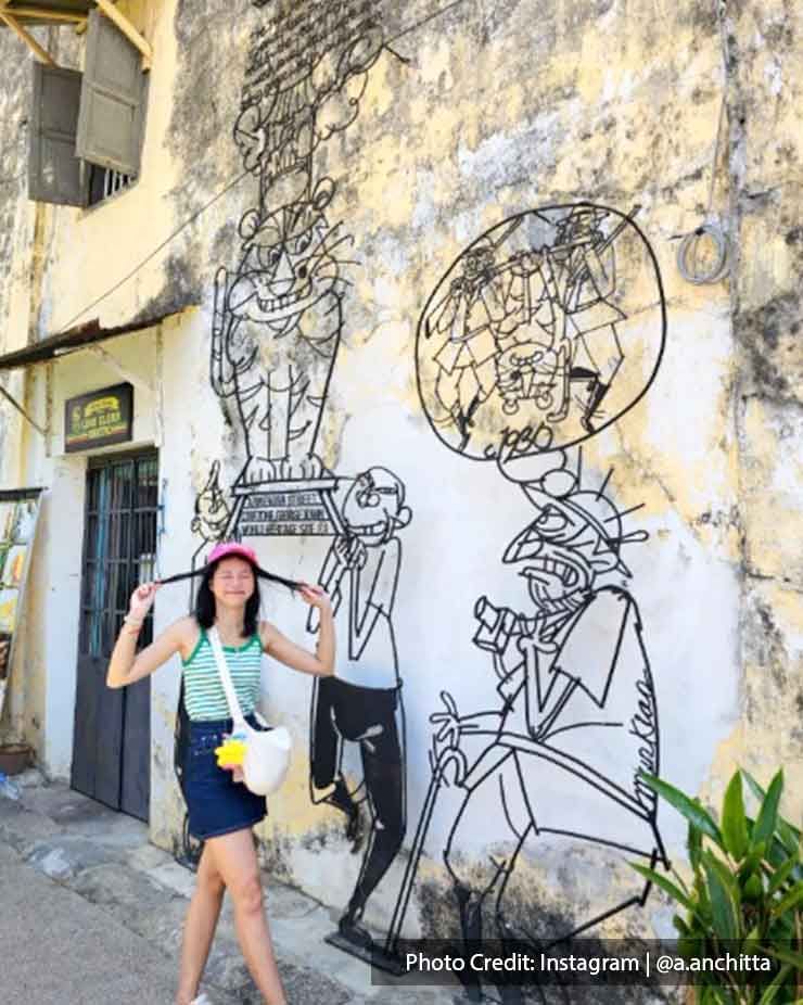 A tourist was taking a picture in Penang Street Art - Lexis Suites Penang