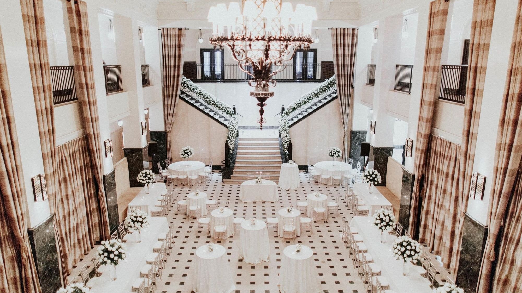 Grand Hall event room with tables and flowers at The Mayo Hotel in Tulsa.