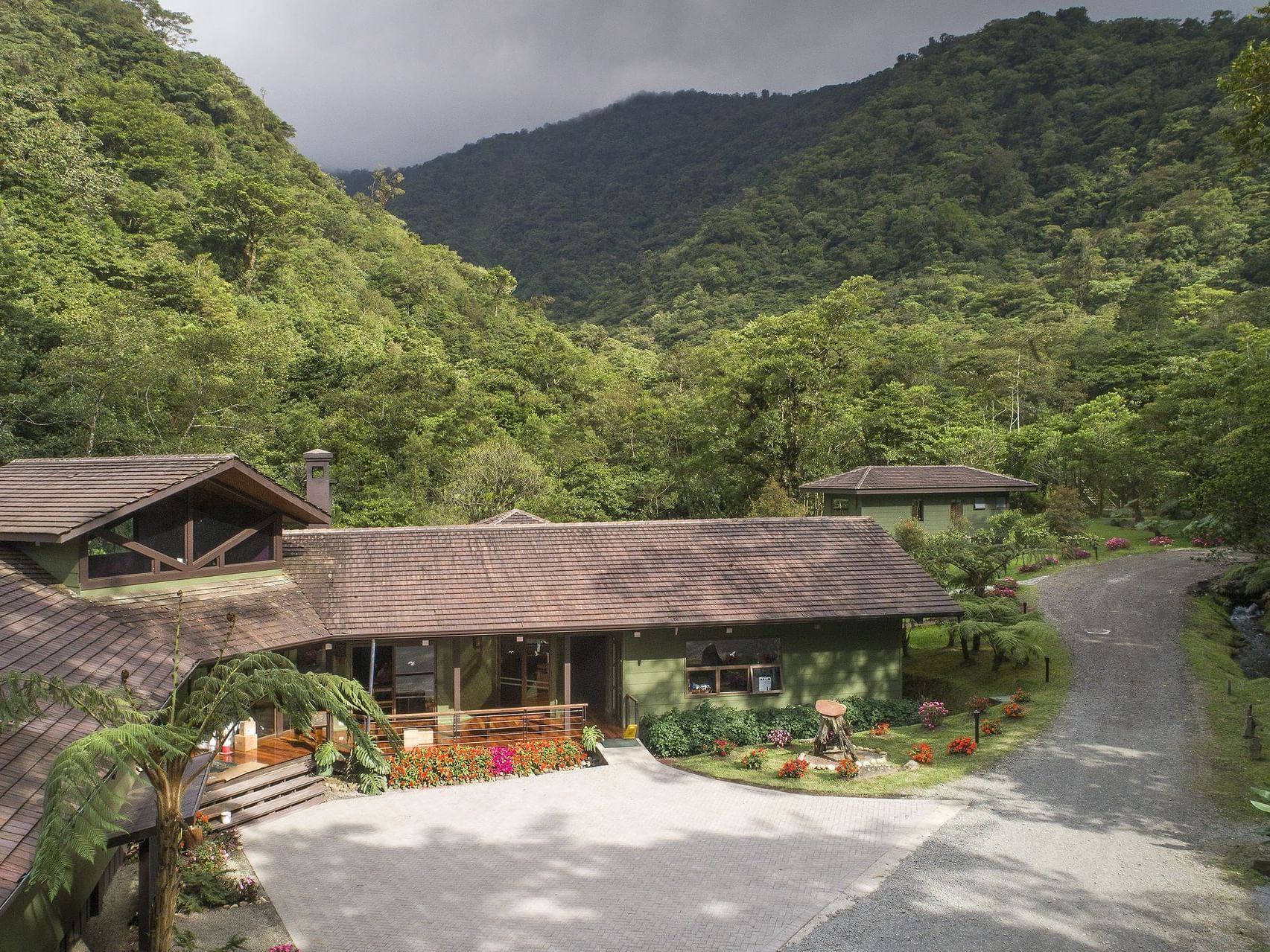 exterior of main lodge building with mountains and driveway