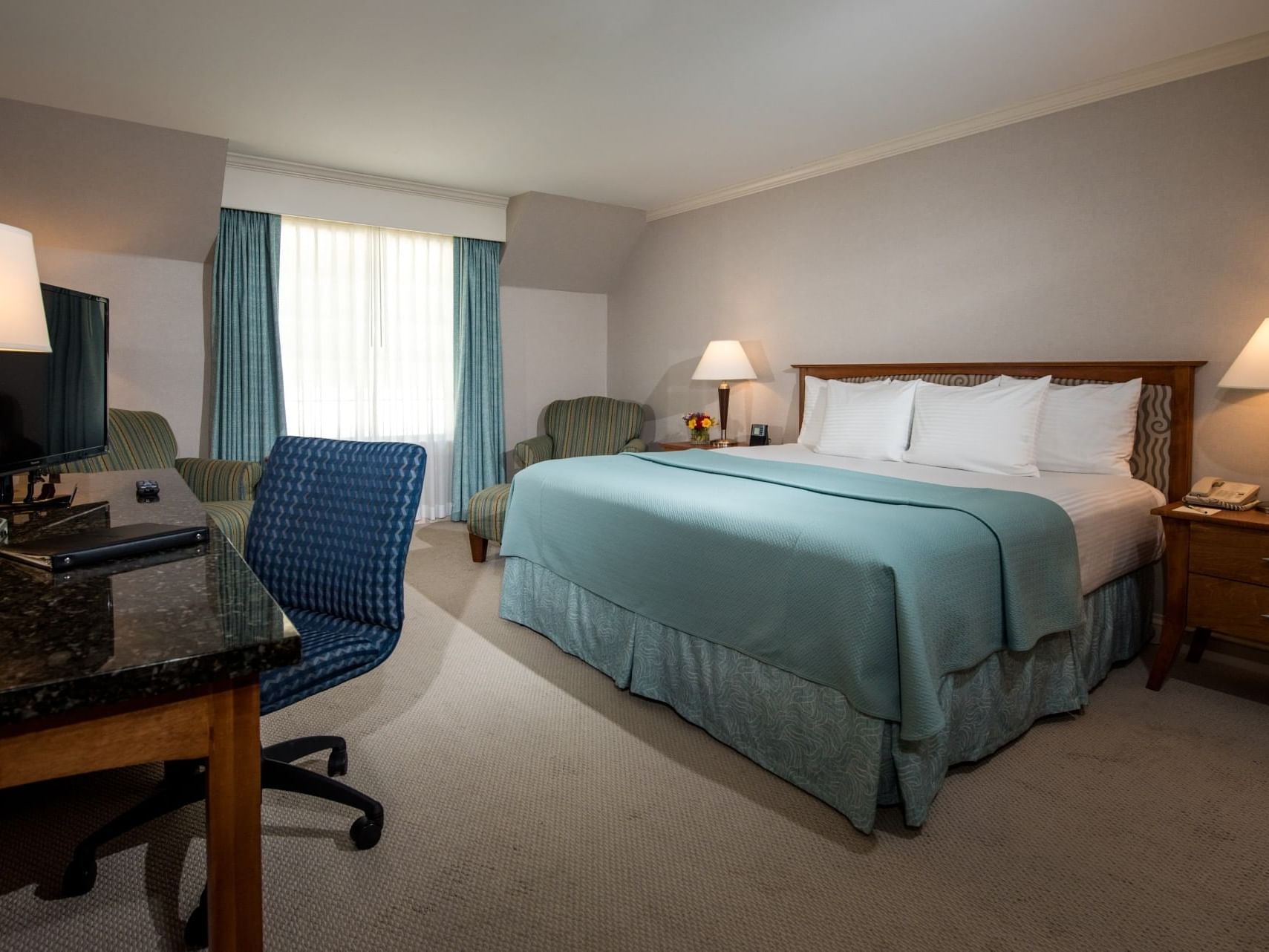 Work desk & TV in 1 King Bed Premium Room with carpeted floors at Gorges Grant Hotel