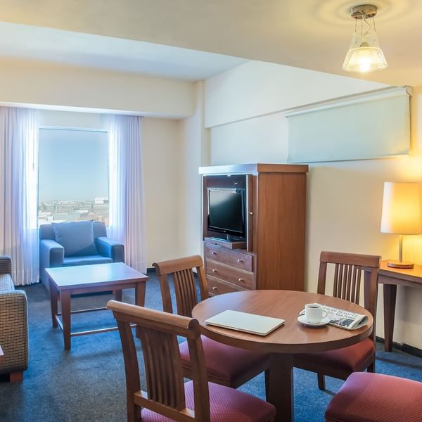 Living area with dining table in Junior Suite at Fiesta Inn