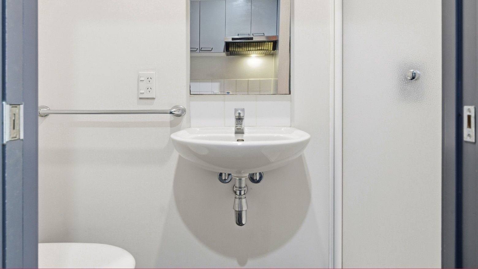 Modern white bathroom with a sink and towel rack at Student Living Auckland - Beach.