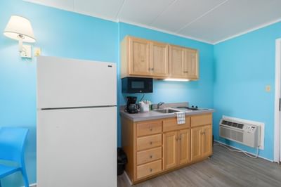 Kitchen with cabinets, refrigerator, microwave, coffee maker and small sink area in HC Ground Floor Poolview at Kokomo Suites