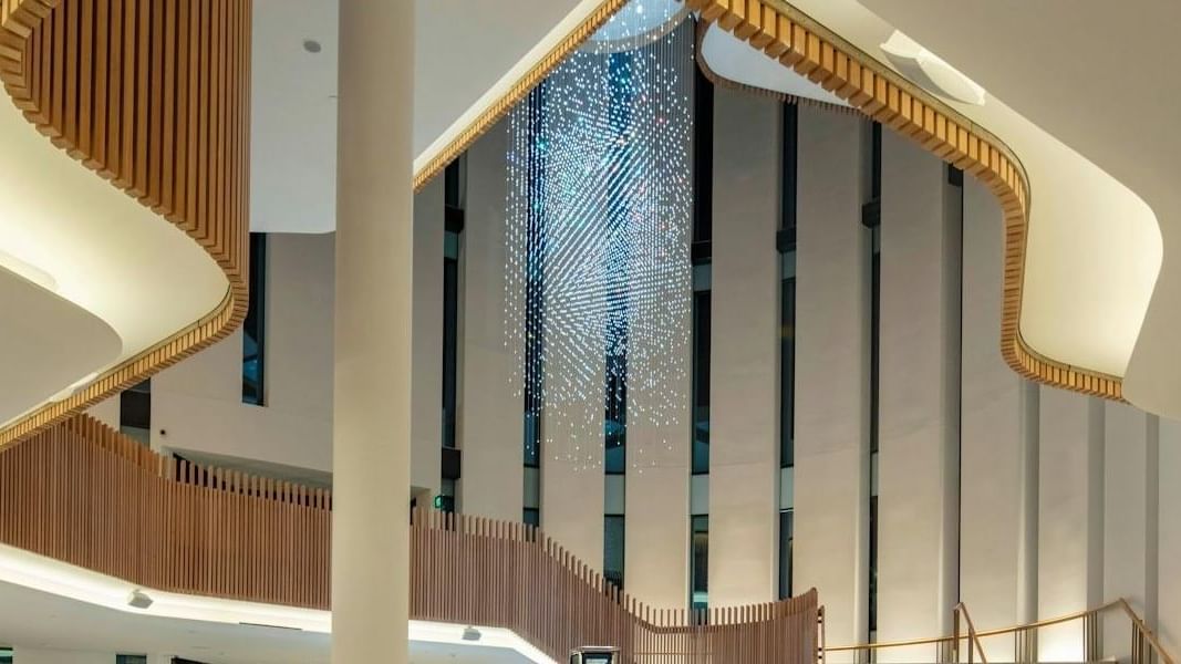 Elegant spiral staircase and modern chandelier at Coliseum Theatre.
