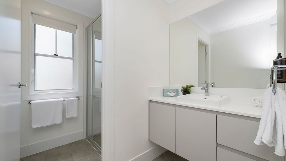 Bathroom featuring a vanity with a mirror, shower, and window in Deluxe Bungalow 2 Bedroom at Mercure Hotel Townsville