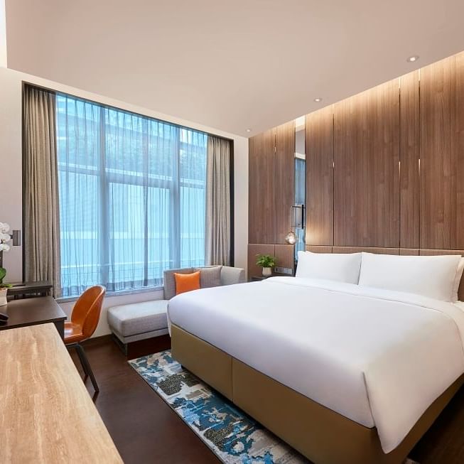 Interior of a modern bedroom with large bed at Amara Hotels