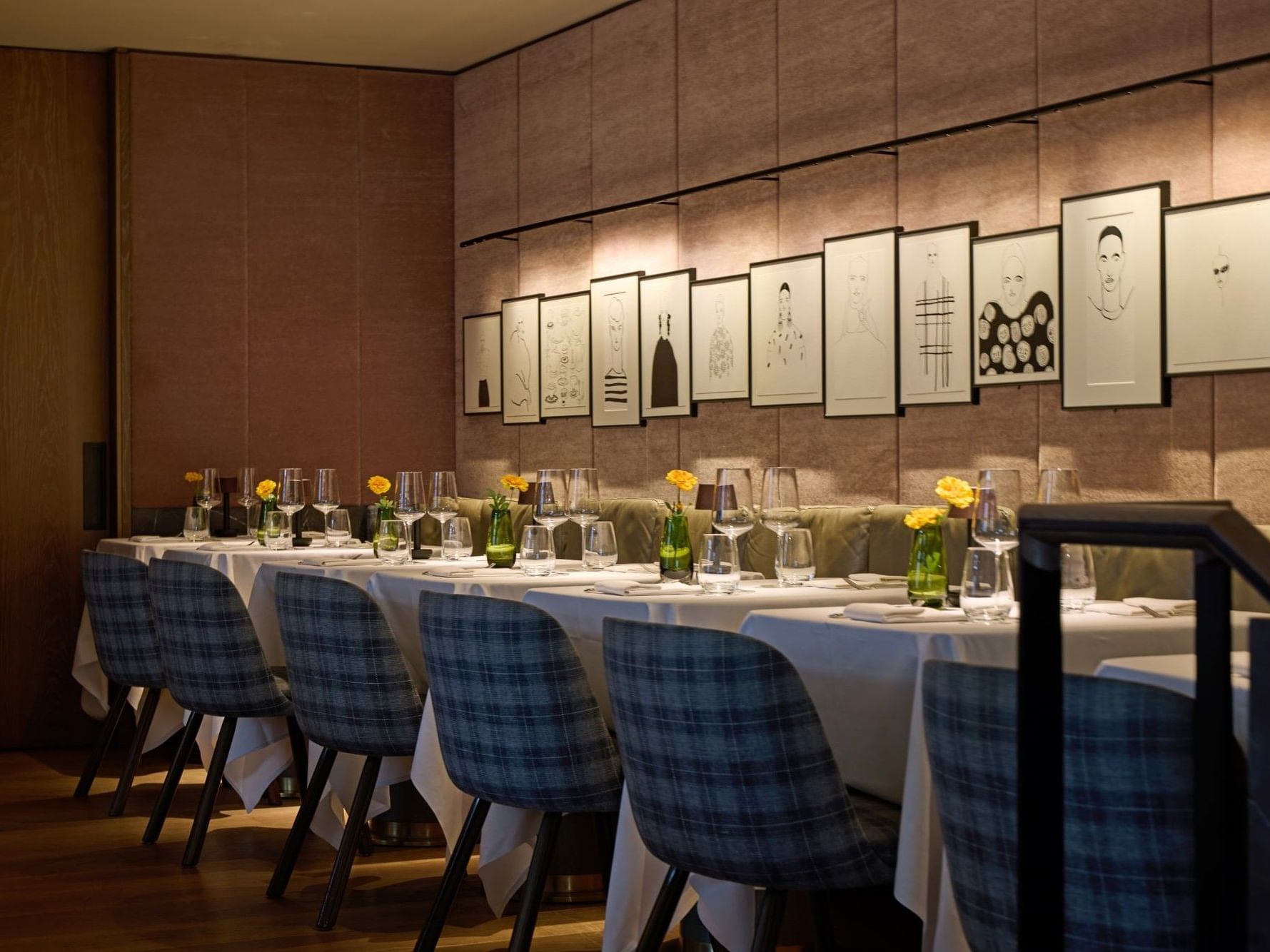 Whitcomb’s restaurant at The Londoner Hotel, with sophisticated wall art, dressed tables, and decorative vases, creating an intimate atmosphere perfect for private dining.