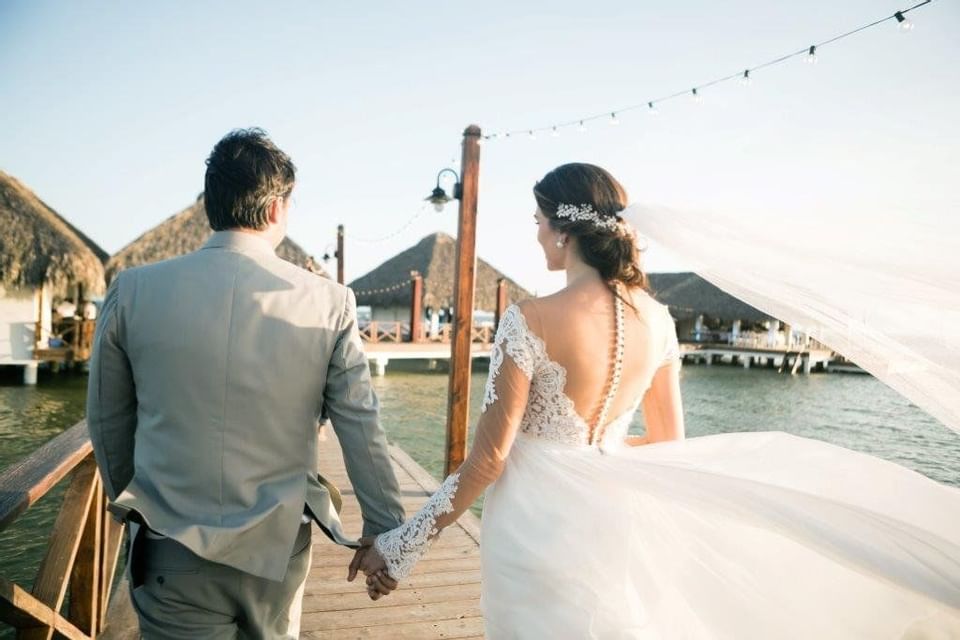 A wedding couple walking along the pier at Club Hemingway