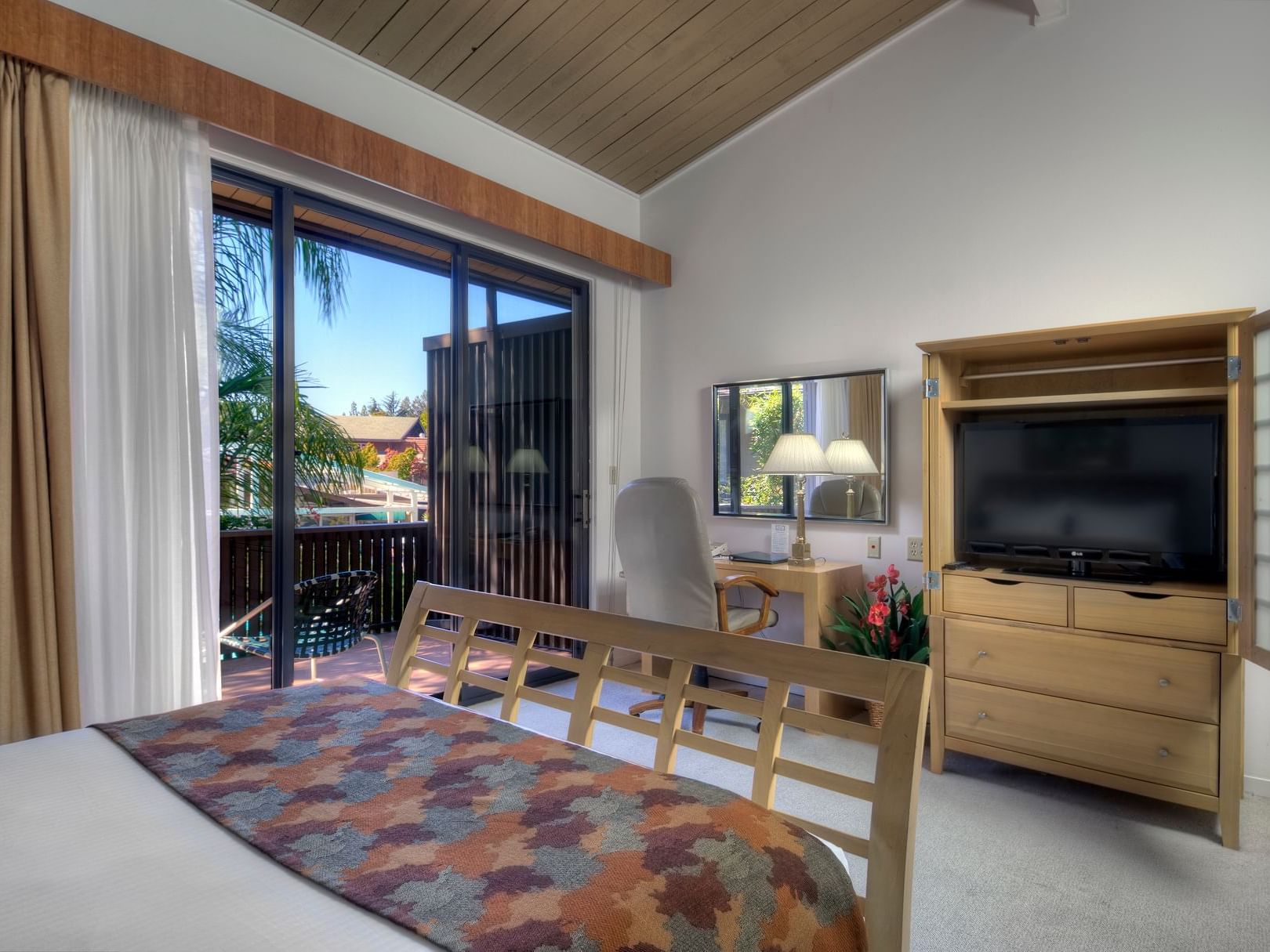 bed facing tv and balcony window