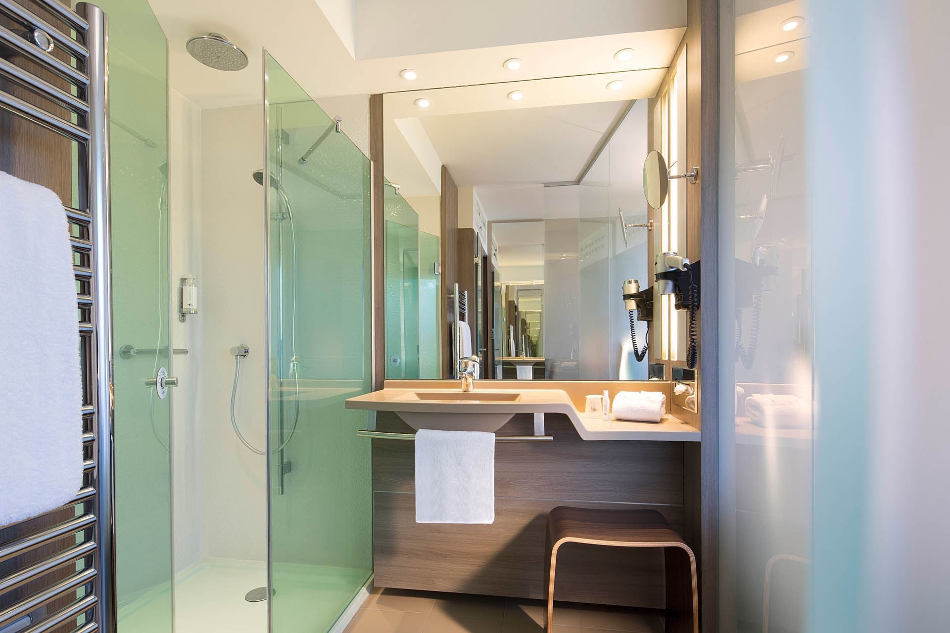 Espace vanité et douche dans une chambre à Oceania Clermont-Ferrand