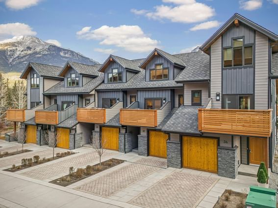 Exterior of Sreamside Villas with wooden accents and mountain backdrop at Spring Creek Vacations