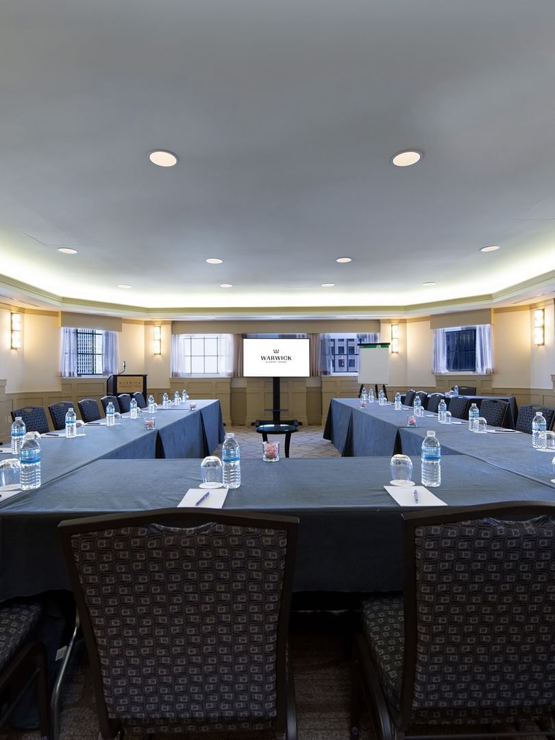 U-shaped table setup with chairs facing the projector screen in Michigan Room at Warwick Allerton Chicago