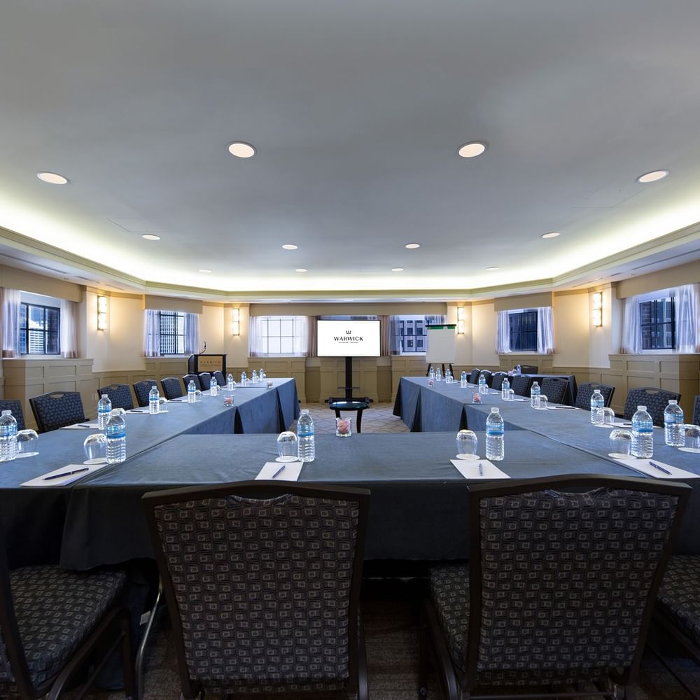 U-shaped table setup with chairs facing the projector screen in Michigan Room at Warwick Allerton Chicago